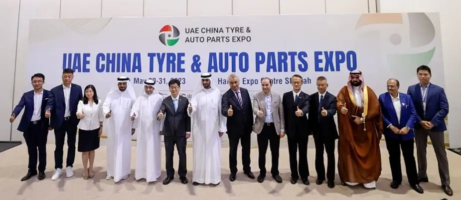 An exhibition hall bustling with activity at the 3rd UAE China Tire & Auto Parts Expo 2024, featuring various booths and attendees engaging in discussions.