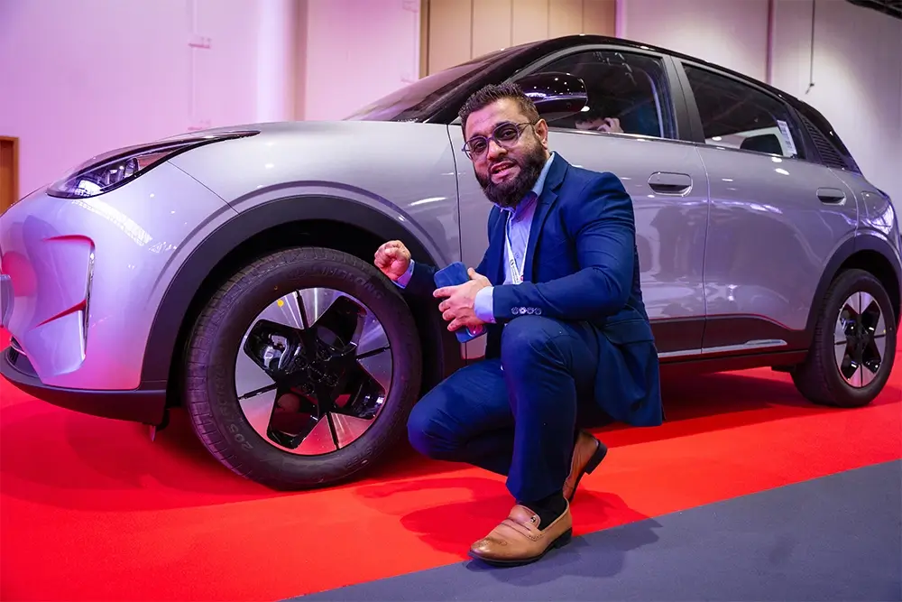 Mr. Muhammad Arif Kabarya poses beside a Chinese electric sports car equipped with Linglong Sport Max tires at the UAE China Tyre & Auto Parts Expo 2025.